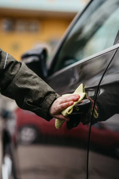 Sarı dezenfektanla dezenfekte edilen kahverengi arabanın kapı kolu. Virüsü ve bakterileri önle, kovid19 'u önle, korona virüsü, alkol dezenfektanı. Evde hijyen kavramı.