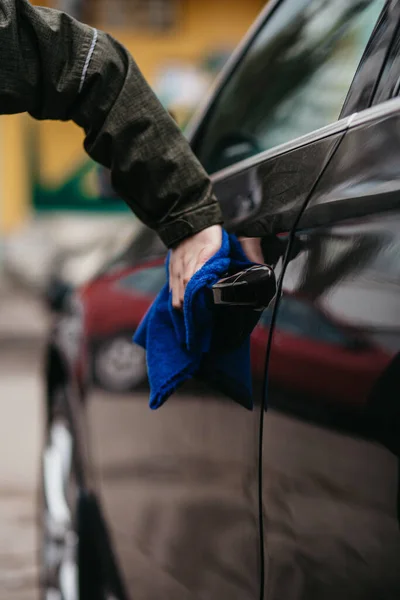 Man\'s hand disinfecting door handle of brown car by blue disinfectant wipe. Prevent the virus and bacterias, Prevent covid19, corona virus, Alcohol Sanitizer. Hygiene concept at home.