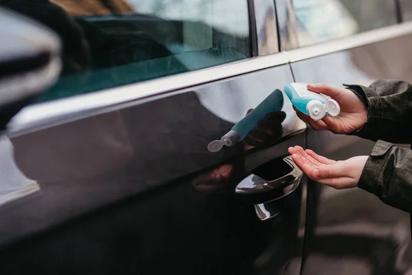 Adamın eli alkol, araba kapısının koluna dezenfektan spreyi, güvenlik, Covid19 enfeksiyonu, korona virüsü, mikrop bulaşması ve bakteri bulaşmasını önlüyor. Alkol dezenfektanı, hijyen konsepti