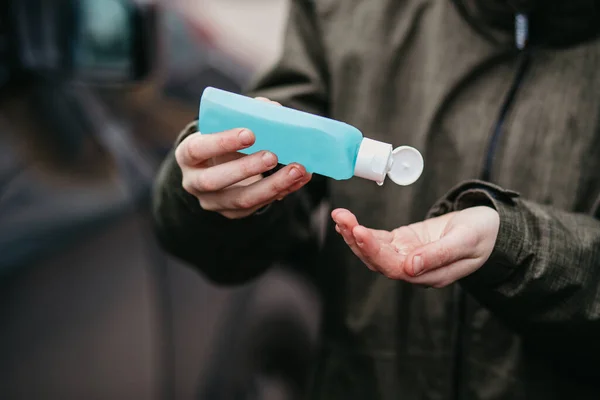 Adamın eli diğer eline alkol jeli sürüyor, güvenlik Covid19 enfeksiyonunu önlüyor, korona virüsü, mikrop veya bakteri bulaşmasını önlüyor. Alkol dezenfektanı, hijyen konsepti.