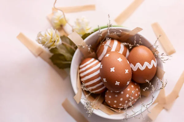 Paskalya bayramı için beyaz desenli kahverengi yumurtalar. Doğal ev yapımı renkli yumurta. Paskalya konsepti. Üst Manzara. Beyaz arka plan. Doğu Avrupa Ortodoks kültürleri için geleneksel.