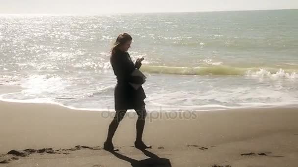 Zakenvrouw lopen voor de strand SMS die brede schot — Stockvideo