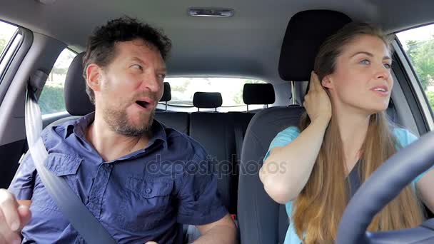 Красивая пара за рулем автомобиля улыбаясь счастливой замедленной съемки — стоковое видео