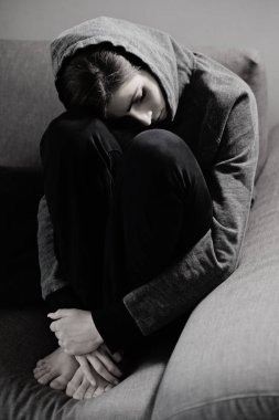 Genç kadın üzgün ve depresyonda diz tutan Divan
