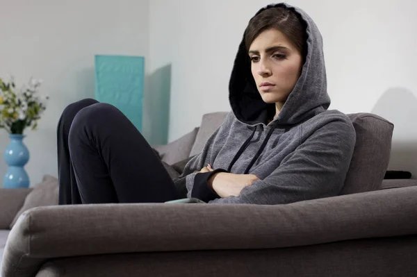 Woman feeling lonely and heart broken at home sitting on sofa — Stock Photo, Image