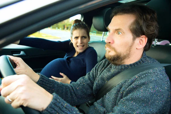 Mujer embarazada gritando a marido asustado en coche —  Fotos de Stock