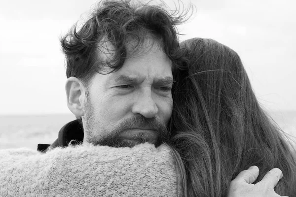 Sad man hugging girlfriend feeling negative and unhappy black and white — Stock Photo, Image