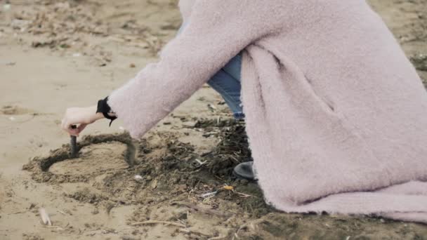 Mulher bonita pintando coração na areia abraçada pelo namorado amoroso — Vídeo de Stock