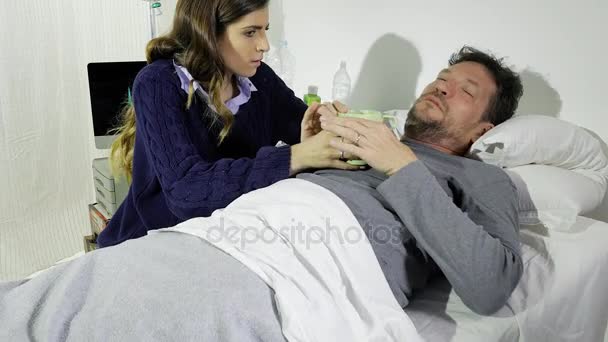 Mulher dando remédio para o namorado doente na cama do hospital — Vídeo de Stock