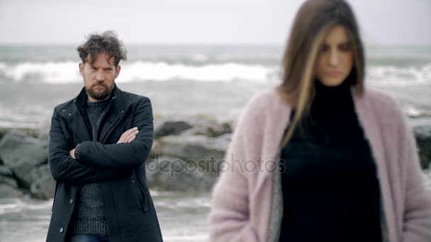 Man in winter in front of ocean looking angry sad girlfriend — Stock Video