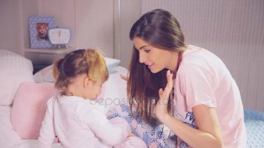 Yatakta sırlarını anlatmaya yastık ile oynayan kız.