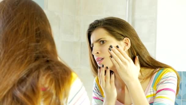 Mujer delante del espejo cubriendo espinilla con maquillaje — Vídeos de Stock