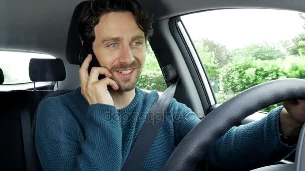 Happy handsome man in car driving and talking on the phone with girlfriend — Stock Video