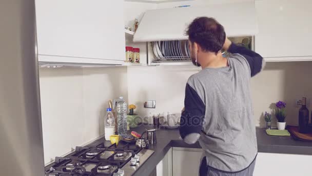 Hombre bailando mientras prepara café en la cocina en pijama . — Vídeo de stock