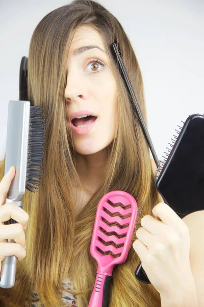 Cute woman with long hair and lots of brushes in hand  funny — Stock Photo, Image