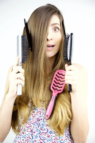 Carino donna con i capelli lunghi e un sacco di spazzole in mano cosa fare — Foto Stock
