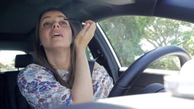 Araba kullanırken, dikkati dağılan bir kadın cep telefonuyla mesaj atıyor