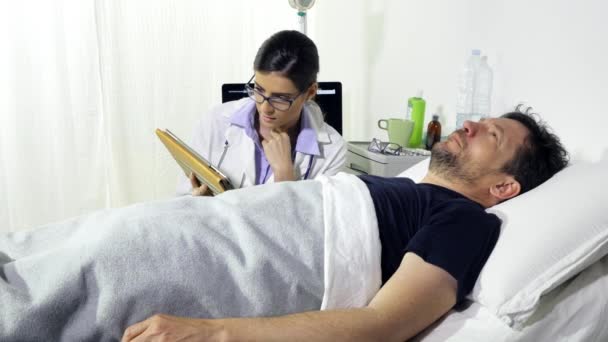 医者と話をするのを心配して病院のベッドに横になった男 — ストック動画