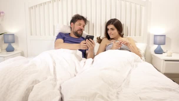 Ευτυχισμένο Ζευγάρι Στο Κρεβάτι Αναζητούν Κοινωνικό Δίκτυο Σχολιάζοντας — Αρχείο Βίντεο