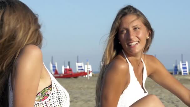 Счастливые девушки на пляже смеются наслаждаясь отпуском — стоковое видео