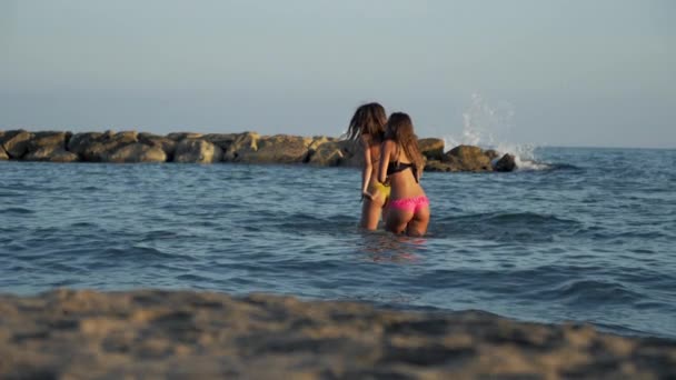 Lindas mujeres jóvenes bailando en el agua en el océano en verano — Vídeo de stock