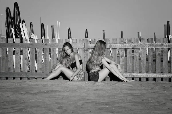 Сумні підлітки в тиші на пляжі не розмовляють після бою чорно-білими — стокове фото