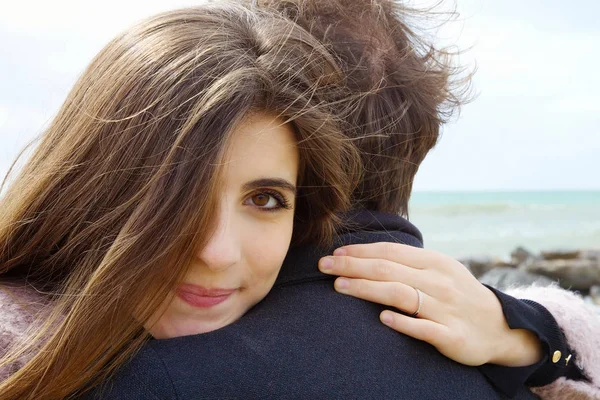 Kvinna i kärlek kramar pojkvän glad ser kameran — Stockfoto