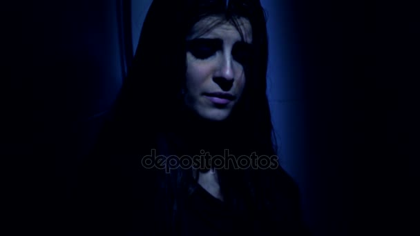 Kvinna sitter ensam och desperat i mörker på natten närbild — Stockvideo