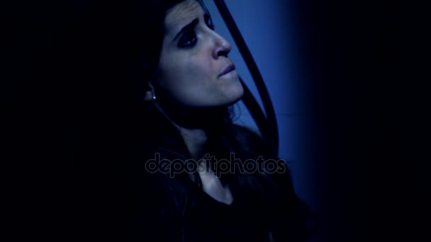 Femme assise seule et désespérée dans les ténèbres la nuit 