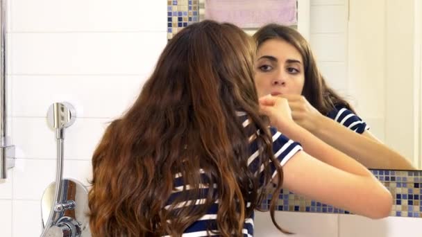 Mujer poniendo cera en el bigote delante del espejo asustada — Vídeos de Stock