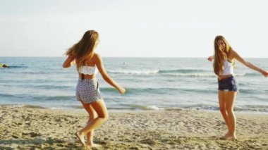 İki mutlu kadın modeller beach retro tarzı ağır çekim üzerinde dans fotoğrafını gimbal