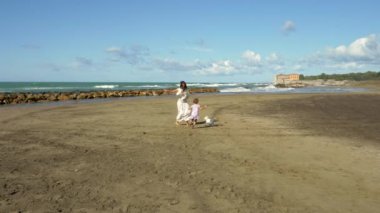  Silah tutan küçük sarışın kızı kamera yavaş seyir okyanus önünde gülümseyen güzel kadın