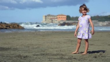 Koşma ve atlama beach süper ağır çekim üzerinde sevimli küçük kız