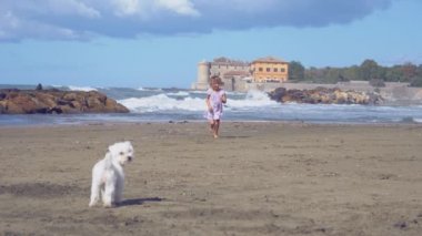 Koşma ve atlama beach süper ağır çekim üzerinde sevimli küçük kız