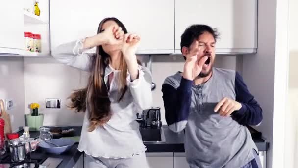 情侣穿着睡衣在厨房里跳舞滑稽的表情慢动作 — 图库视频影像