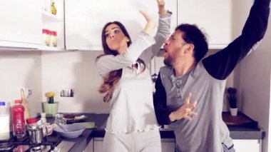Mutlu komik deli çift pijama ağır çekimde mutfakta dans