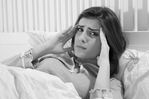 Λυπημένη γυναίκα στο κρεβάτι με ισχυρό πονοκέφαλο μαύρο και άσπρο — Φωτογραφία Αρχείου