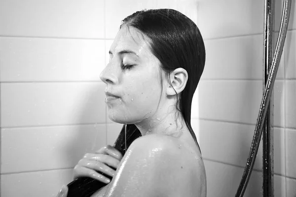 Happy young woman taking shower at home black and white — Stock Photo, Image