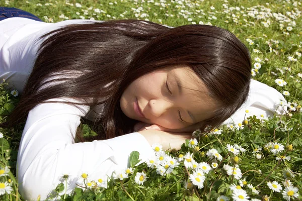 Boldog ázsiai nő fekve alszik, pihenő Park, a tavaszi fű — Stock Fotó