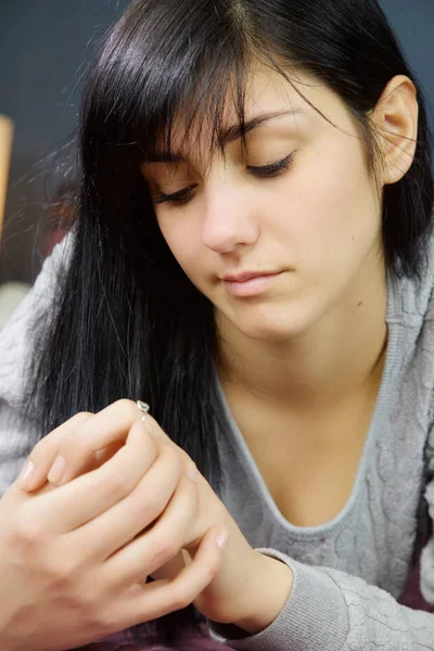 Jovem mulher olhando anel de noivado pensando — Fotografia de Stock