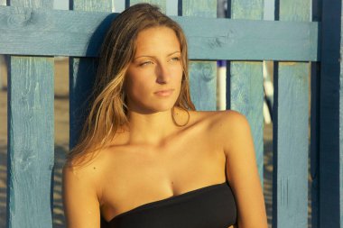 Kumsalda gün batımını izlemek mutlu sarışın kadın