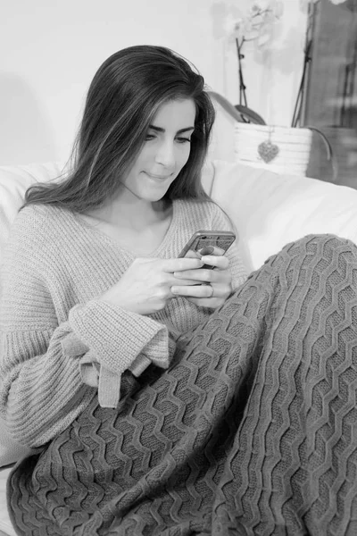 Happy woman using smartphone sending sms black and white — Stock Photo, Image