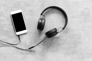 Kulaklık ve bir telefon beton zemin üzerine