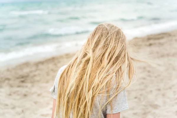 Chica rubia joven de pie en la playa —  Fotos de Stock