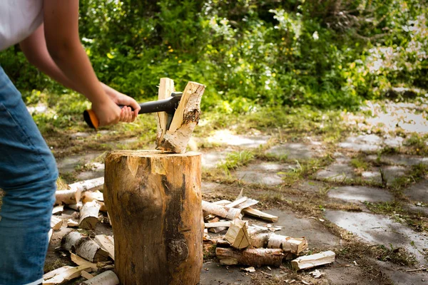 Молодий чоловік з сокирою рубає деревину на подрібнювальному блоці — стокове фото