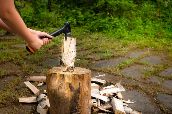Молодий чоловік з сокирою рубає деревину на подрібнювальному блоці — стокове фото