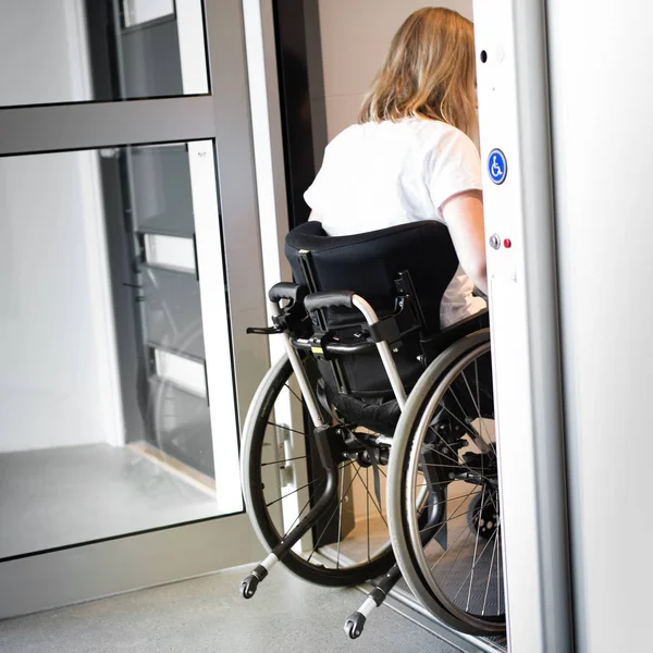 Persona en silla de ruedas que entra en un ascensor —  Fotos de Stock