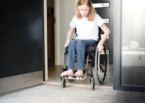 Persona en silla de ruedas que se mueve por una puerta baja —  Fotos de Stock