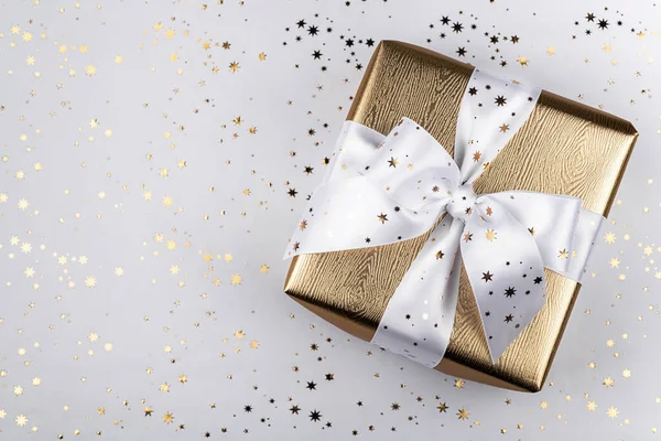 Scatola regalo oro con un nastro bianco . — Foto Stock