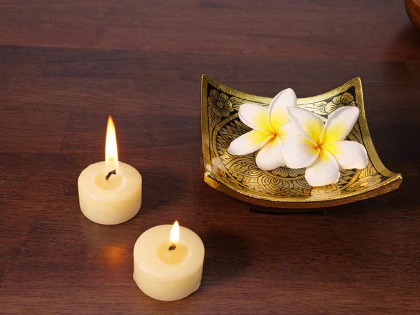 Две свечи, блюдо из золота и цветы — стоковое фото